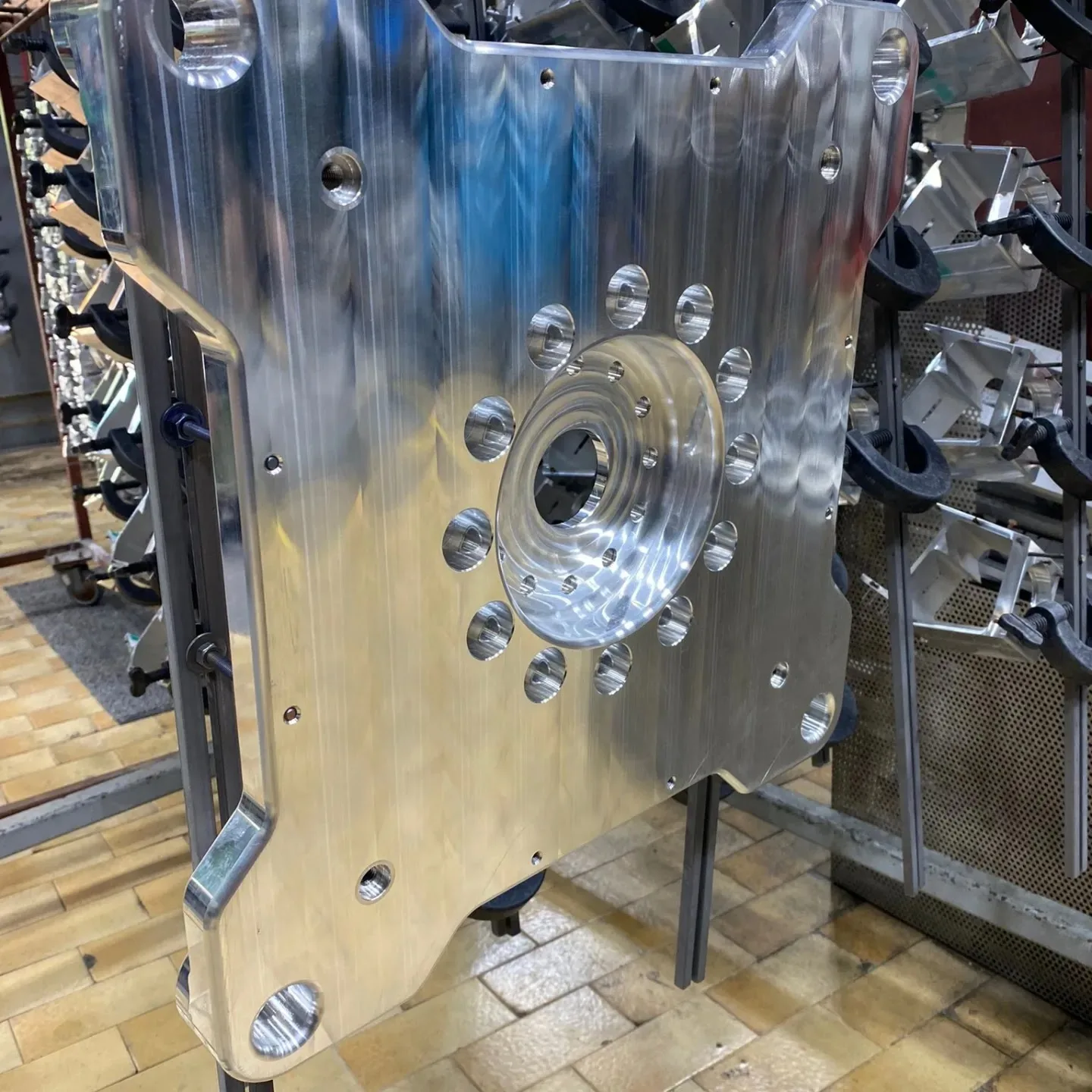 Große gefräste Aluminiumplatte mit vielen Bohrungen am Gestell in der Halle
