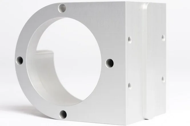Natur eloxierter Aluminiumblock mit großem Rundausschnitt vor weißem Hintergrund