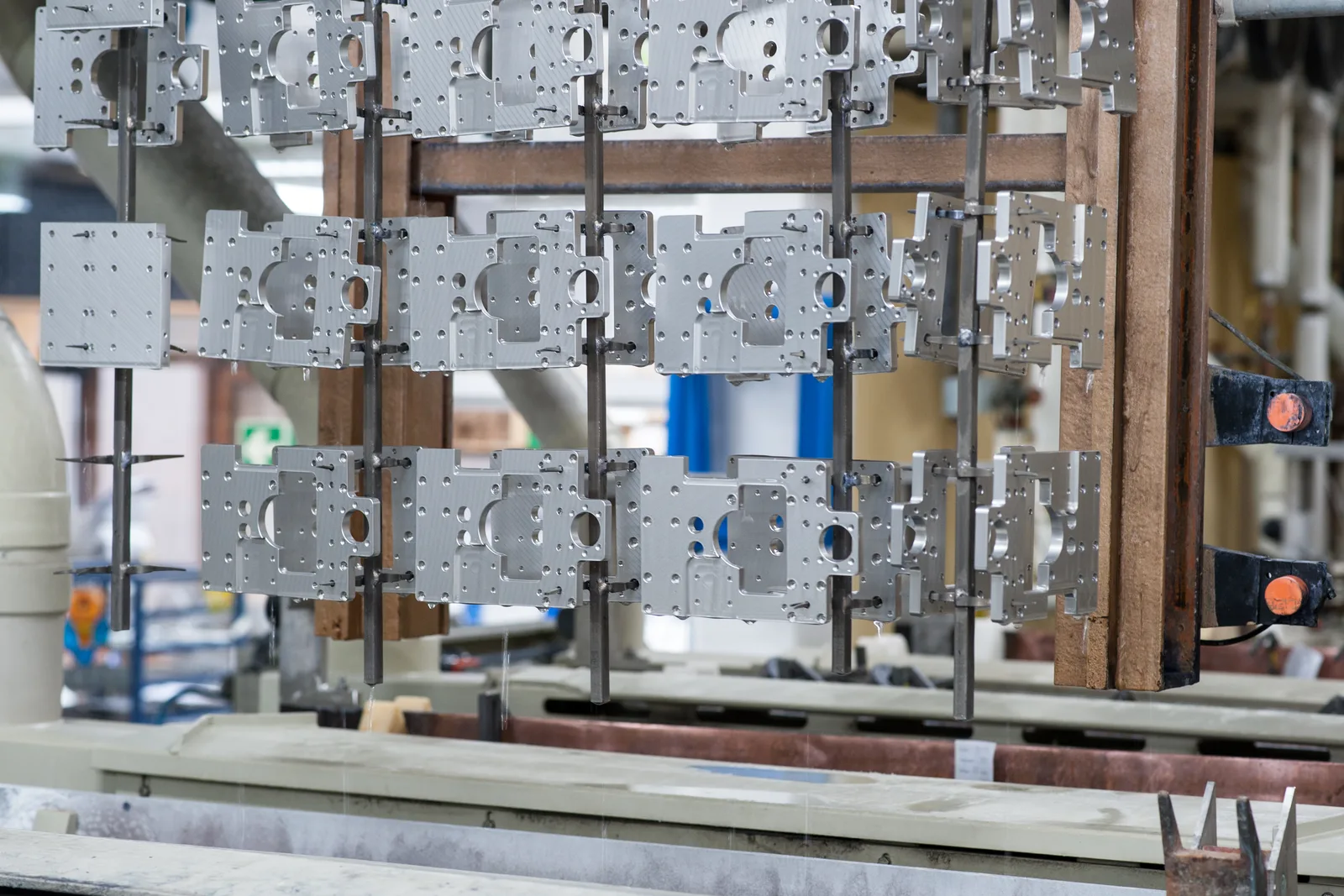Gestelle mit Aluminiumplatten hängen über den Becken der Anlage